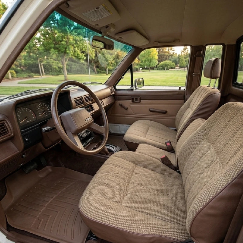 Inside the restored cab: tan cloth seats, brown door trim, a brown dashboard and the steering wheel